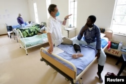 Un infirmier aide à traiter la tuberculose d'un patient à l'hôpital de Tugela en Afrique du sud, le 28 octobre 2008.