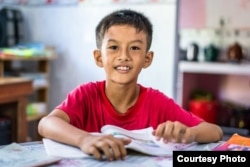 Nguyen Hoang Men, 9, studies in the home of a neighboring teacher during summer recess for his elementary school in Hoa Loi Commune, Tra Vinh Province, Vietnam, July 3, 2018. (©Gates Archive/Quinn Ryan Mattingly)