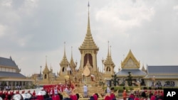 The ceremonial urn of Thailand's late King Bhumibol Adulyadej arrives at the crematorium during the funeral procession as royal crematorium is seen in the background in Bangkok, Thailand, Oct. 26, 2017.