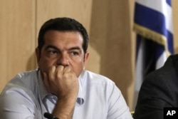 Greek Prime Minister Alexis Tsipras listens during his visit at the transport ministry in Athens, Aug. 12, 2015.