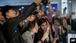 Attendees take pictures of the new Huawei Mate X foldable 5G smartphone during the Mobile World Congress wireless show, in Barcelona, Spain, Monday, Feb. 25, 2019. (AP Photo/Emilio Morenatti)