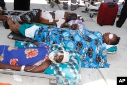 Critically wounded men wait to be moved into a Turkish air ambulance plane to airlift injured patients for treatment in Turkey, in Mogadishu, Somalia, Oct,16, 2017.