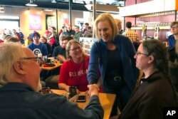 FILE - Sen. Kirsten Gillibrand, D-N.Y. greets patrons at Stomping Grounds Cafe in Ames, Iowa, Jan. 19, 2019.