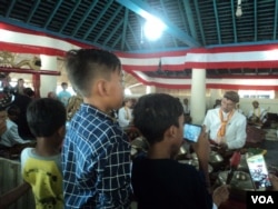 Sejumlah anak merekam video dengan gawai saat prosesi tabuhan gamelan sekaten di Masjid Agung Solo. (Foto: VOA/Nurhadi)