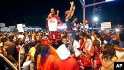 Protesters stand on cars as they congregate at N. Foster Dr. and Fairfields Ave., the location of the Triple S convenience store in Baton Rouge, La., Wednesday, July 6, 2016.