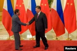 FILE - Chinese President Xi Jinping (R) shakes hands with Philippines President Rodrigo Duterte prior to their bilateral meeting during the Belt and Road Forum, at the Great Hall of the People in Beijing, China, May 15, 2017.
