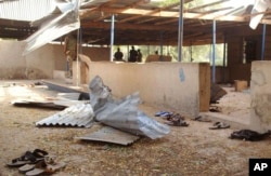 FILE - Nigeria troops, rear, provide security at the area where a bomb exploded in Nigeria's northeastern University of Maiduguri at Maiduguri, Nigeria, Jan. 16, 2016.