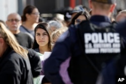 FILE - People line up to cross into the United States from Tijuana, Mexico, at the San Ysidro port of entry in San Diego, Nov. 19, 2018.