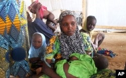 FILE - A family of refugees that fled their homes due to violence from the Islamic extremist group Boko Haram sit inside a refugee camp in Minawao, Cameroon, Feb. 25, 2015.
