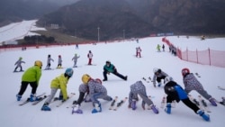 School children warm up before skiing at the Vanke Shijinglong Ski Resort in Yanqing outside of Beijing, China, on December 23, 2021. (AP Photo/Ng Han Guan)