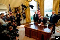 President Donald Trump, flanked by Health and Human Services Secretary Tom Price, left, and Vice President Mike Pence, meets with members of the media regarding the health care overhaul bill, Friday, March 24, 2017, in the Oval Office.