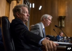 Sen. Rand Paul, R-Ky., left, and Sen. Rob Portman, R-Ohio, pose questions to witnesses as the Senate Committee on Foreign Relations holds a hearing on relations between the U.S. and Russia, in Washington, Aug. 21, 2018.