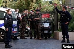 Police and soldiers secure the scene where French soliders were hit and injured by a vehicle in the western Paris suburb of Levallois-Perret, France, Aug. 9, 2017.
