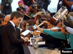Actor Eddie Redmayne signs autographs during the red carpet event for the movie "The Danish Girl" at the 72nd Venice Film Festival, northern Italy, Sept. 5, 2015.