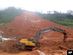 FILE - Heavy equipment is used as rescue workers search for survivors and victims following a mudslide in Regent, east of Freetown, Sierra Leone, Aug. 14, 2017.
