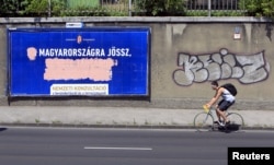 Government billboards vilifying immigrants destroyed by opposition activists are seen in Budapest, Hungary, June 10, 2015. A spoof Hungarian political party is mocking the government's anti-immigrant rhetoric.