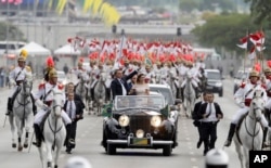 Presiden Brasil Jair Bolsonaro bersama ibu negara Michelle Bolsonaro, melambaikan tangan kepada warga Brazil saat mengendarai mobil terbuka seusai upacara pelantikannya, di Brasilia, Brasil, 1 Januari 2019.
