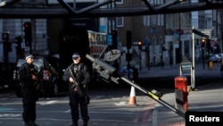 Naoružani policajci stoje u blizini Borou marketa u Londonu