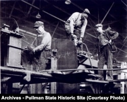 Three riveters working on a Pullman Car ca 1949; black and white men worked together in the factory.
