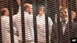 FILE - A Nov. 2013 image made from video provided by Egypt's Interior Ministry shows ousted President Mohammed Morsi (R), speaking from the defendant's cage during a trial hearing in Cairo, Egypt.