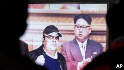 Sebuah layar TV di Seoul, Korea Selatan menunjukkan gambar pemimpin Korea Utara Kim Jong Un (kanan) dan kakak tirinya, Kim Jong Nam (14/2).