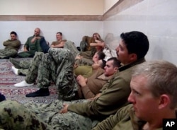 This picture released by the Iranian Revolutionary Guards on Wednesday, Jan. 13, 2016, shows detained American Navy sailors in an undisclosed location in Iran