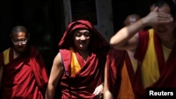 FILE - Tibetan monks walk in an alley at Majnu Ka Tila, a Tibetan refugee camp in New Delhi, India, April 27, 2016.