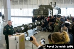RUSSIA -- Lt. Gen. Mikhail Matveevsky, the chief of the military's missile and artillery forces, left, speaks during a briefing by the Russian Defense Ministry, as the 9M729 land-based cruise missile, center, is displayed near its launcher.