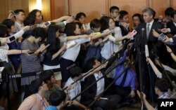 FILE – Then-U.S. State Department’s Special Representative for North Korea Policy Sung Kim, right, answers reporters' questions after a meeting about North Korea with envoys from South Korea and Japan, May 27, 2015.