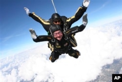 FILE - Former President George H.W. Bush during free fall with U.S. Army Golden Knights parachute team member, Sgt. 1st Class Mike Elliott, College Station, Texas, Nov. 2007.