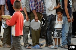 FILE - Nepalese people line up at a relief camp for survivors of the Nepal earthquake in Kathmandu, May 19, 2015. Turmoil can lead to a surge in human trafficking, according to human rights activists.