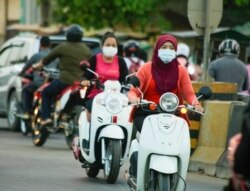 ពលរដ្ឋ​កម្ពុជាពាក់ម៉ាស់​ ពេល​ធ្វើ​ដំណើរ​តាម​ដងផ្លូវ​ ខណៈ​កម្ពុជា​កំពុង​ប្រឈម​ការ​រាតត្បាត​នៃ​ជំងឺកូវីដ១៩​ នៅ​ភ្នំពេញ ថ្ងៃទី១០ ខែមីនា​ ឆ្នាំ២០២១។​ (ហ៊ាន​ សុជាតា/វីអូអេ)​