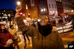 A protester yells as others gather for a march on the Capitol Building, Jan. 18, 2017, in Washington.