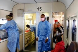 Médecins et patients à l'intérieur du train de la clinique mobile de soins de santé à Soweto, le 22 juin 2021.