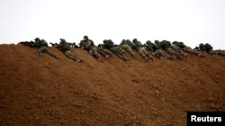 Israeli soldiers are seen next to the border fence on the Israeli side of the border with the northern Gaza Strip, Israel.