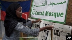 Darlene Derosier menempelkan petunjuk cara membersihkan diri, atau berwudhu, di Masjid Al-Fattah di Gressier, Haiti. (AP)
