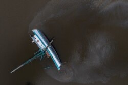 Bahan bakar bocor dari kapal terbalik di sepanjang Bayou Lafourche akibat hantaman Badai Ida di Galliano, Louisiana, AS, 31 Agustus 2021.