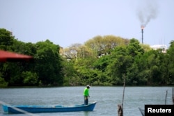 FILE - A fisherman navigates in front of the Pemex oil port know as Dos Bocas in Paraiso, Tabasco, Mexico, April 24, 2018.