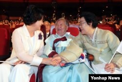 문재인 대통령 부인 김정숙(왼쪽) 여사가 15일 세종문화회관에서 열린 제72주년 광복절 경축식에서 일본군 위안부 피해자 길원옥(가운데)ㆍ이용수 할머니의 손을 잡고 이야기를 나누고 있다.