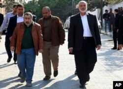 Hamas' supreme leader, Ismail Haniyeh, center right, tours destroyed buildings, in Gaza City, March 27, 2019. Haniyeh made his first public appearance since a new round of cross-border violence with Israel this week.