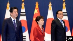 Japan's prime minister and South Korea's president appear with Chinese Premier Li Keqiang, right, during the trilateral summit in Seoul, South Korea.