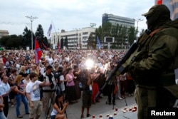 A pro-Russian separatist stands guard during a rally in support of Novorossiya on Lenin Square in the center of the eastern Ukrainian city of Donetsk, July 13, 2014.