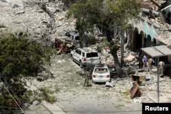 Security personnel are seen next to buildings damaged at the scene where a suicide car bomb exploded targeting a Mogadishu hotel in a business center in Maka Al-Mukaram street in Mogadishu, Somalia, March 1, 2019.