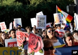 FILE - Protesters march through downtown Phoenix, May 1, 2017. Immigrant and union groups marched in cities across the United States on Monday to mark May Day and protest against President Donald Trump's efforts to boost deportations.