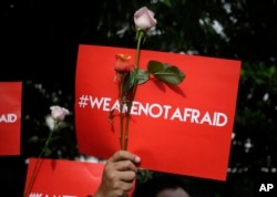 FILE - An activist holds a poster during a rally condemning a Jan. 15, 2016, attack, outside a cafe where it took place in Jakarta, Indonesia. Islamic State claimed responsibility for the attack.