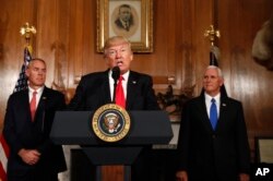 FILE - President Donald Trump, flanked by Interior Secretary Ryan Zinke, left, and Vice President Mike Pence, speaks at the Interior Department in Washington, Wednesday, April 26, 2017, before signing an Antiquities Executive Order. The president is asking for a review of the designation of tens of millions of acres of land as national monuments.