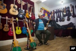 Passang Topgyal, a 38-year-old exile Tibetan, tests a Tibetan stringed musical instrument called a piwang at his instrument shop in Dharmsala, India, June 20, 2017.