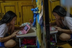 Seorang mahasiswa tahun pertama, memulai pembelajaran online dari rumah menggunakan ponselnya sebagai ilustrasi. (Foto: AFP)