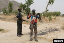 FILE - Members of a civilian vigilante group stand guard at the border with Nigeria in Kerawa, Cameroon, March 16, 2016. Kerawa is on the border with Nigeria and is subject to frequent Boko Haram attacks.