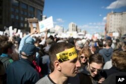 A man displays a sticker on his head with portrait of Moscow mayor Sergei Sobyanin reading 'Enough!', as people gather for a rally in Moscow, Russia, May 14, 2017.